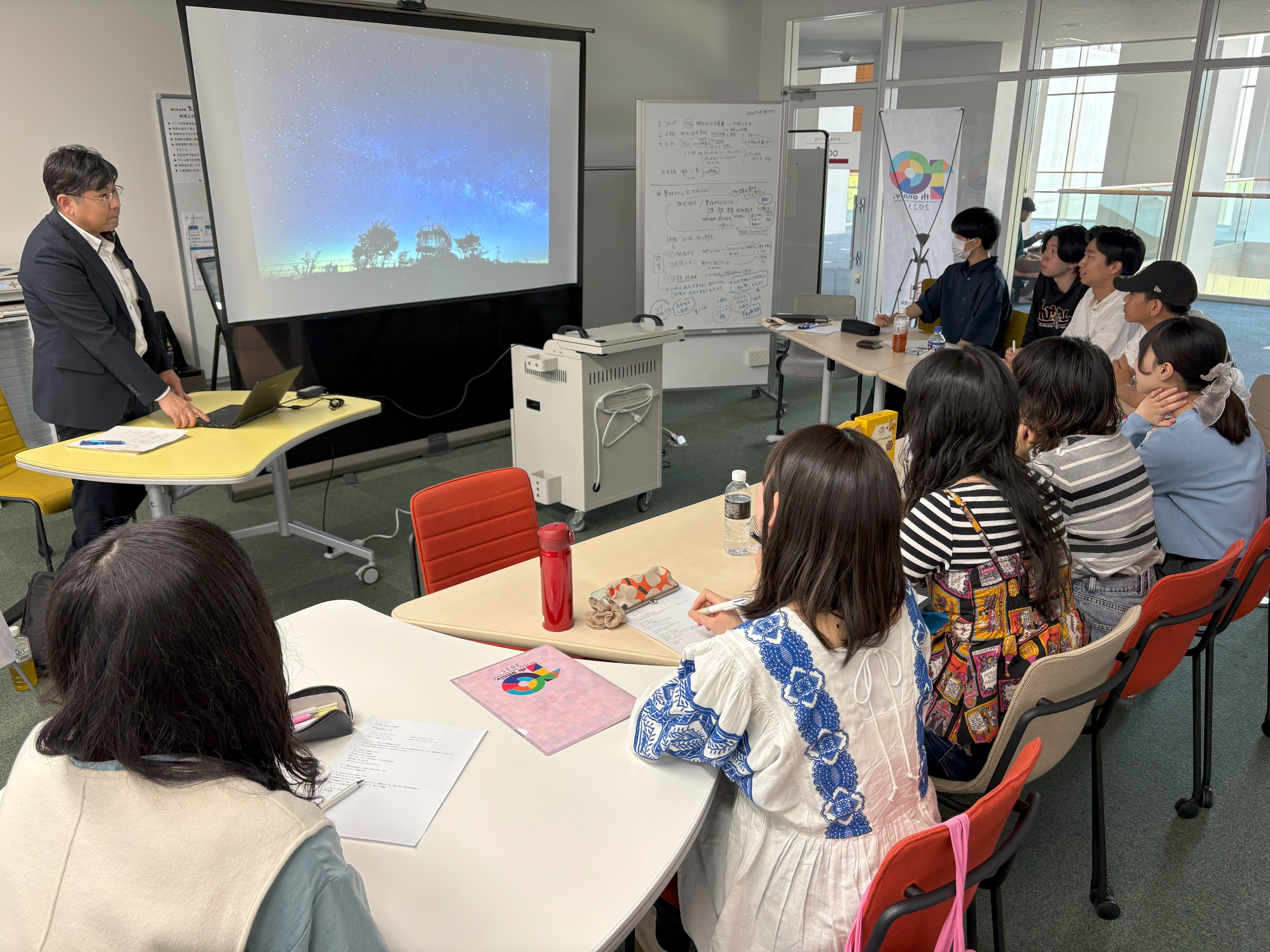 現代社会学部4年の三矢ゼミ生たちが、学びの拠点oasiSで豊根村役場職員 青山さんのお話を聞く様子